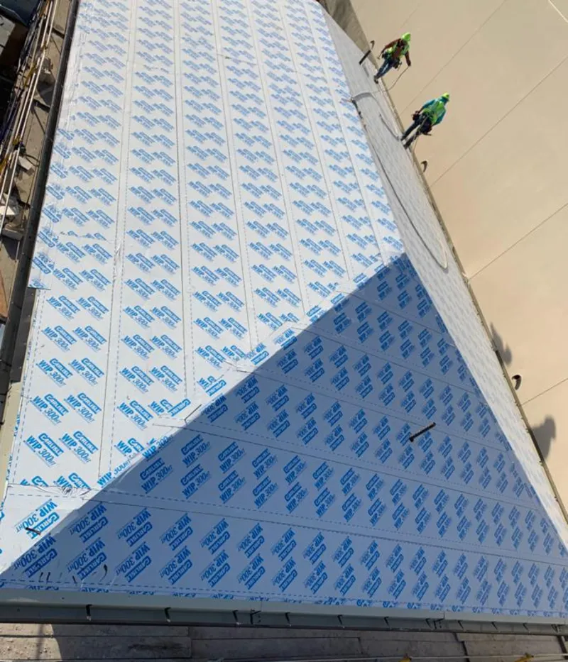 Professional roofers installing underlayment on a metal roof in Bethany